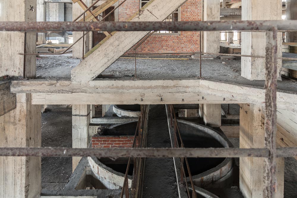 beeld van de binnenkant van de verlaten kolenwasserij die als
            urbex locatie gekend is als the House of Escher